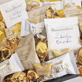 Flowpack kurv med guld lækkerier som chokolade, skumfiduser og lakrids
